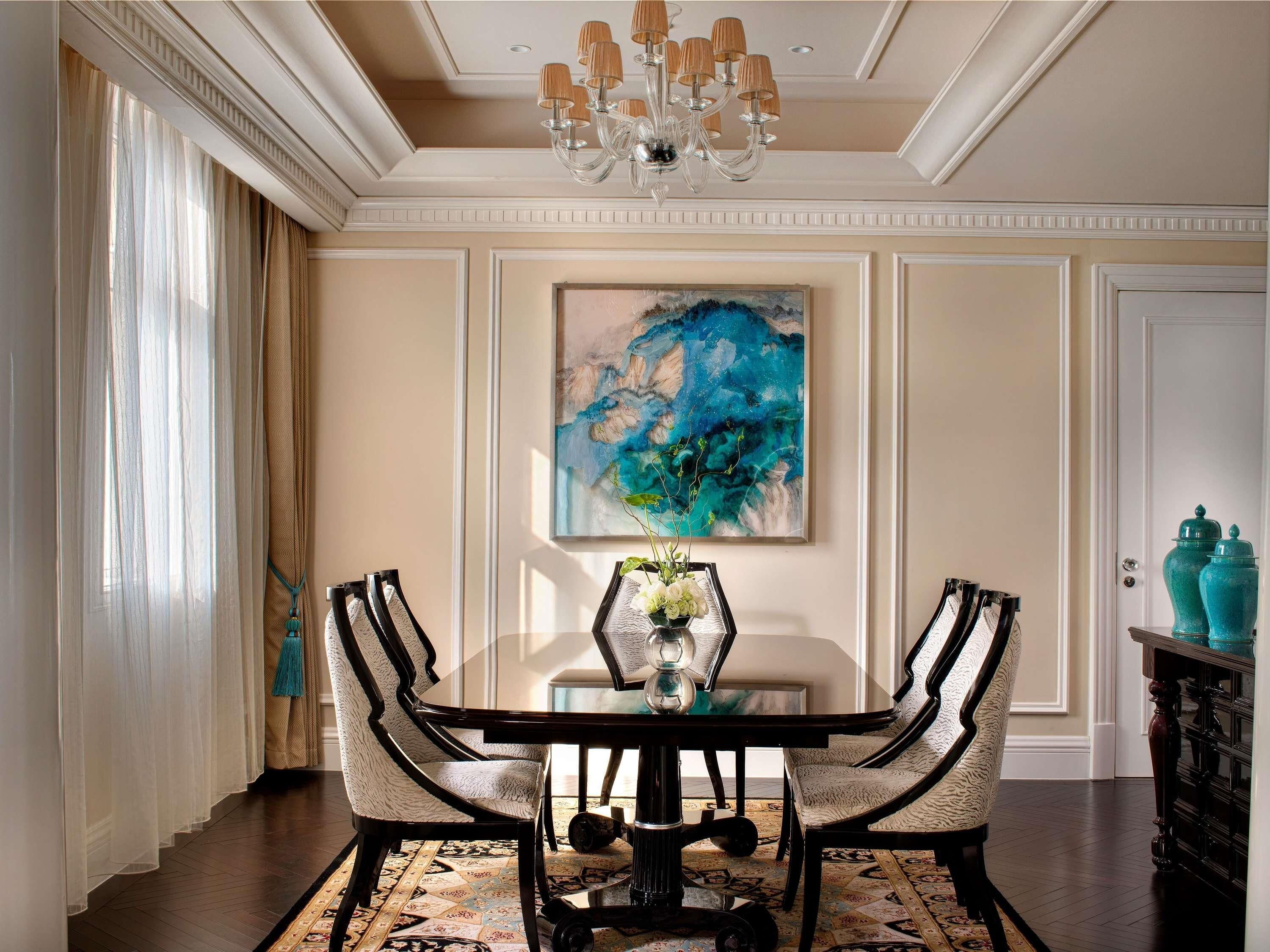 A dining room with a table, chairs, a chandelier, a painting, and a cabinet.