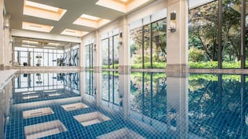 Una piscina techada, sillones reclinables de piscina