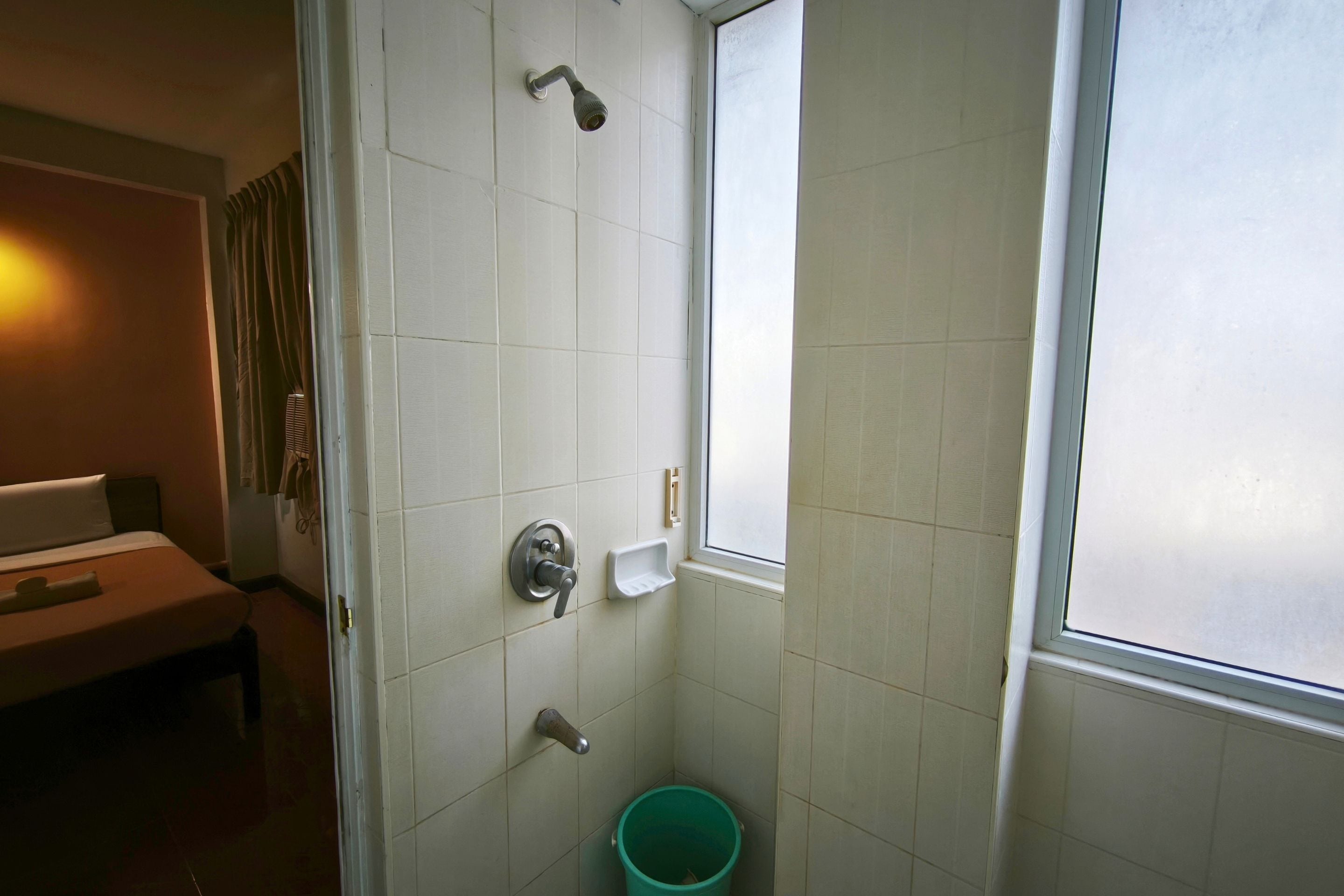 Un baño con ducha, inodoro, lavabo y ventana.