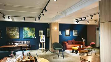 A modern interior with a seating area, art on the walls, and a display of products on the floor.