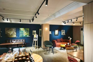 A modern interior with a seating area, art on the walls, and a display of products on the floor. - My Hotel Davao City (Davao)