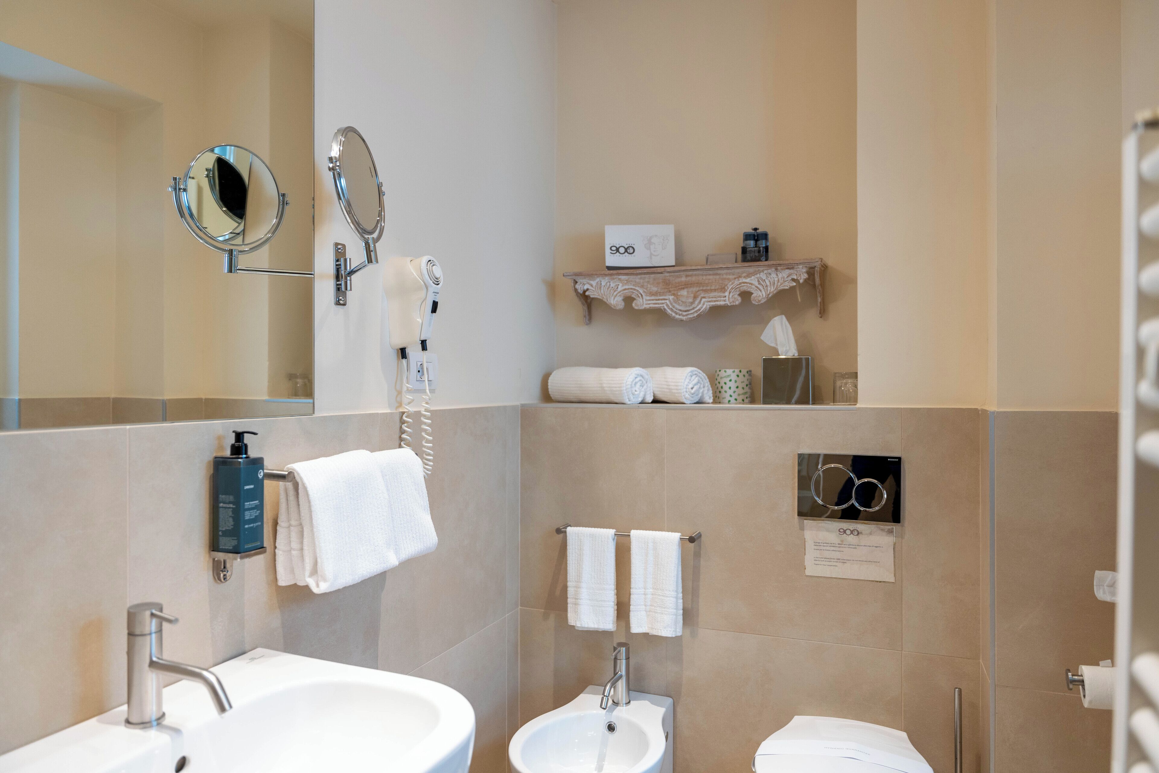 Un baño moderno con lavabo, espejo y toallero.