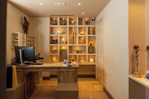 A room with a desk, computer, shelves with decorative items, and a statue. - Hotel 900 (Giulianova)