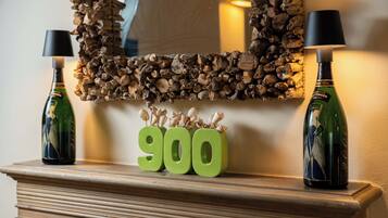A fireplace mantel with two bottles, a mirror, and the number 900.