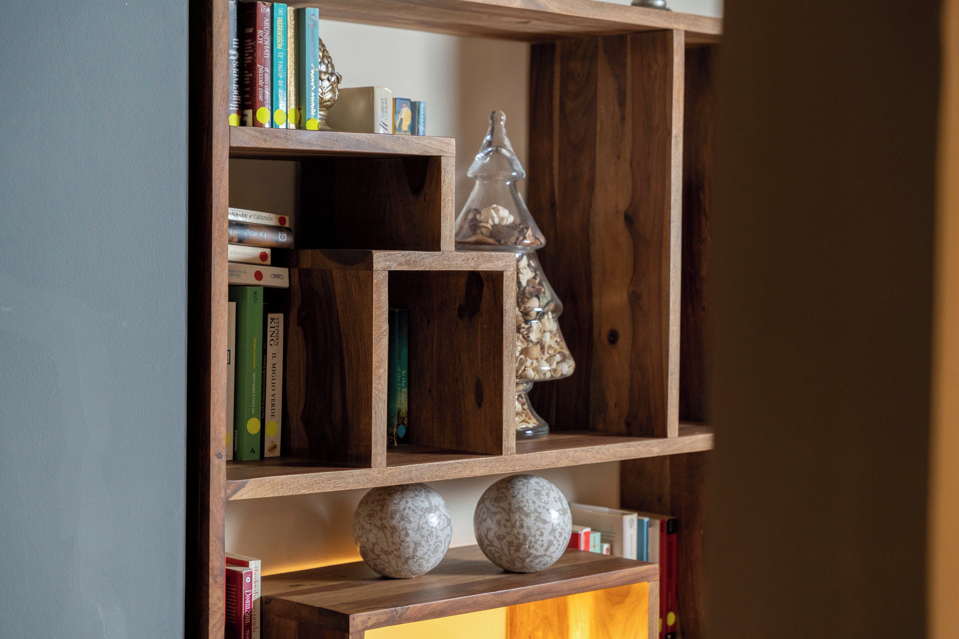A wooden bookshelf with books and decorative items.