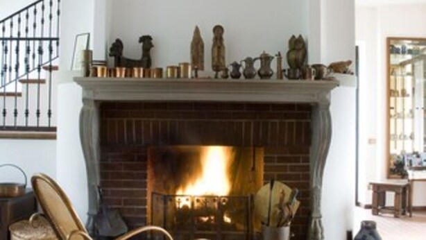 A cozy living room with a fireplace, a rocking chair, and a staircase. - Bed and Breakfast Casa Nini (Lierna)