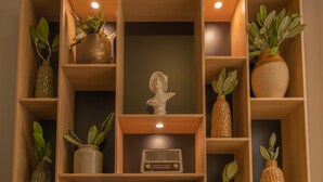 A wooden bookshelf with decorative items, including vases, a radio, and books. - CALM Appart' & Hostel (Lille)