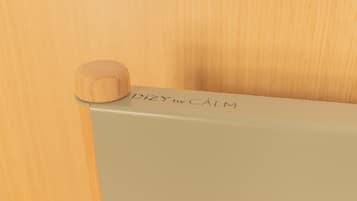 A wooden object with 'DIZY by CALM' engraved on a light-colored surface.