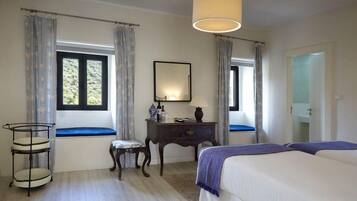 A bedroom with a bed, bedside table, lamp, and a window with curtains.