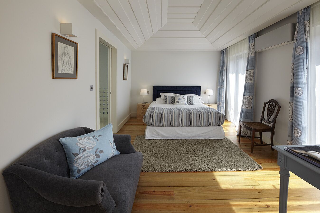 Una camera da letto con un letto, un divano, una sedia e una scrivania.