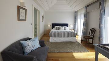 Una camera da letto con un letto, un divano, una sedia e una scrivania.