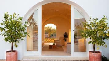 Un interior moderno con un amplio arco que da a una sala de estar con sofá y mesa de centro.