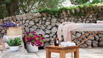 Relax in our serene spa area, featuring a soothing stone backdrop, a comfortable bench, and a tranquil atmosphere.