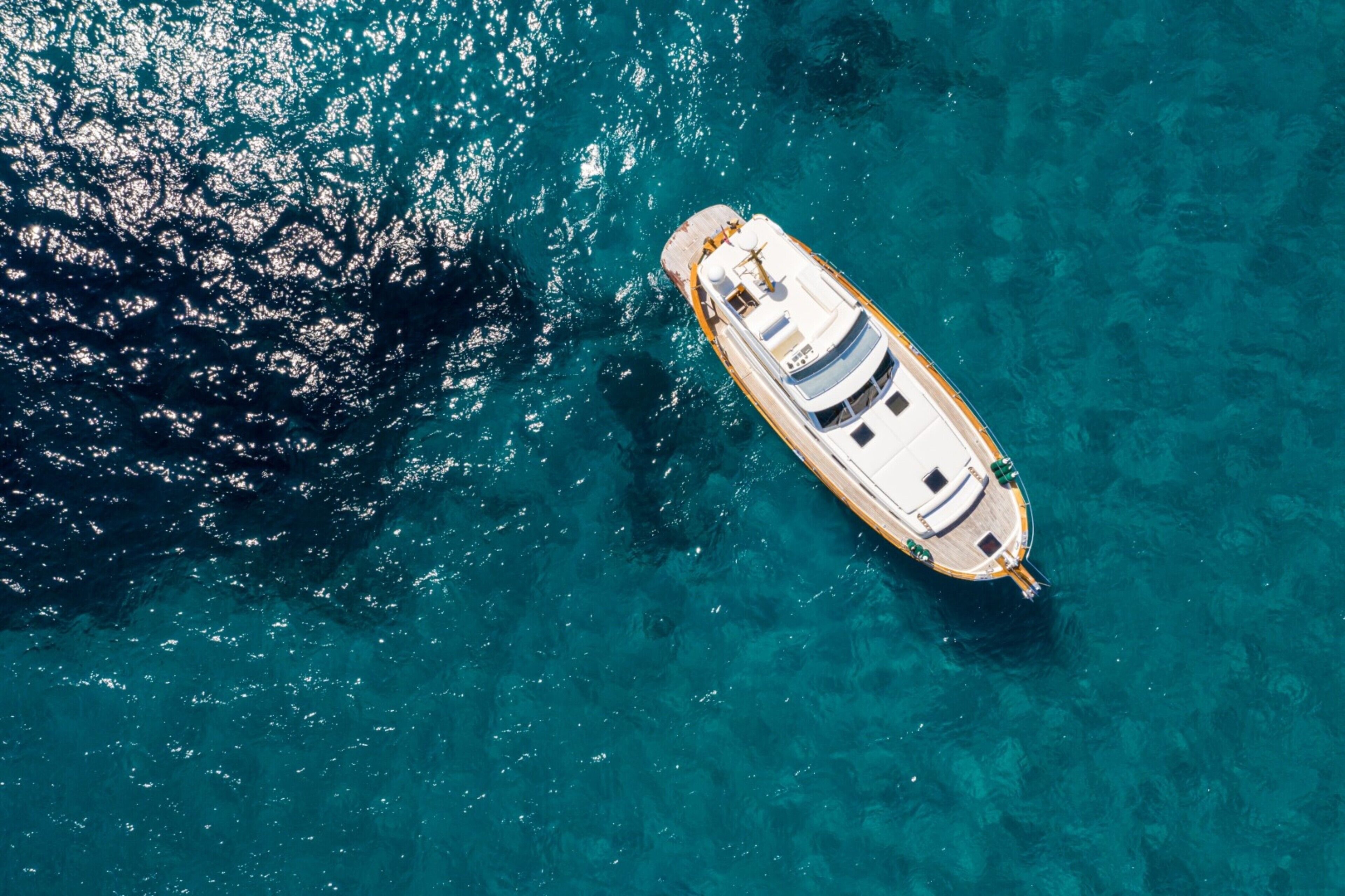 Luchtbeeld van een boot op helder turquoise water.