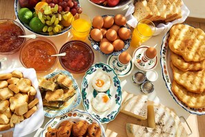 A breakfast spread with various foods and drinks. - Perigiali Hotel (Skiros)