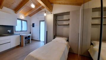 Ein Schlafzimmer mit einem Bett, einem Einbauschrank und einer Küchenzeile.