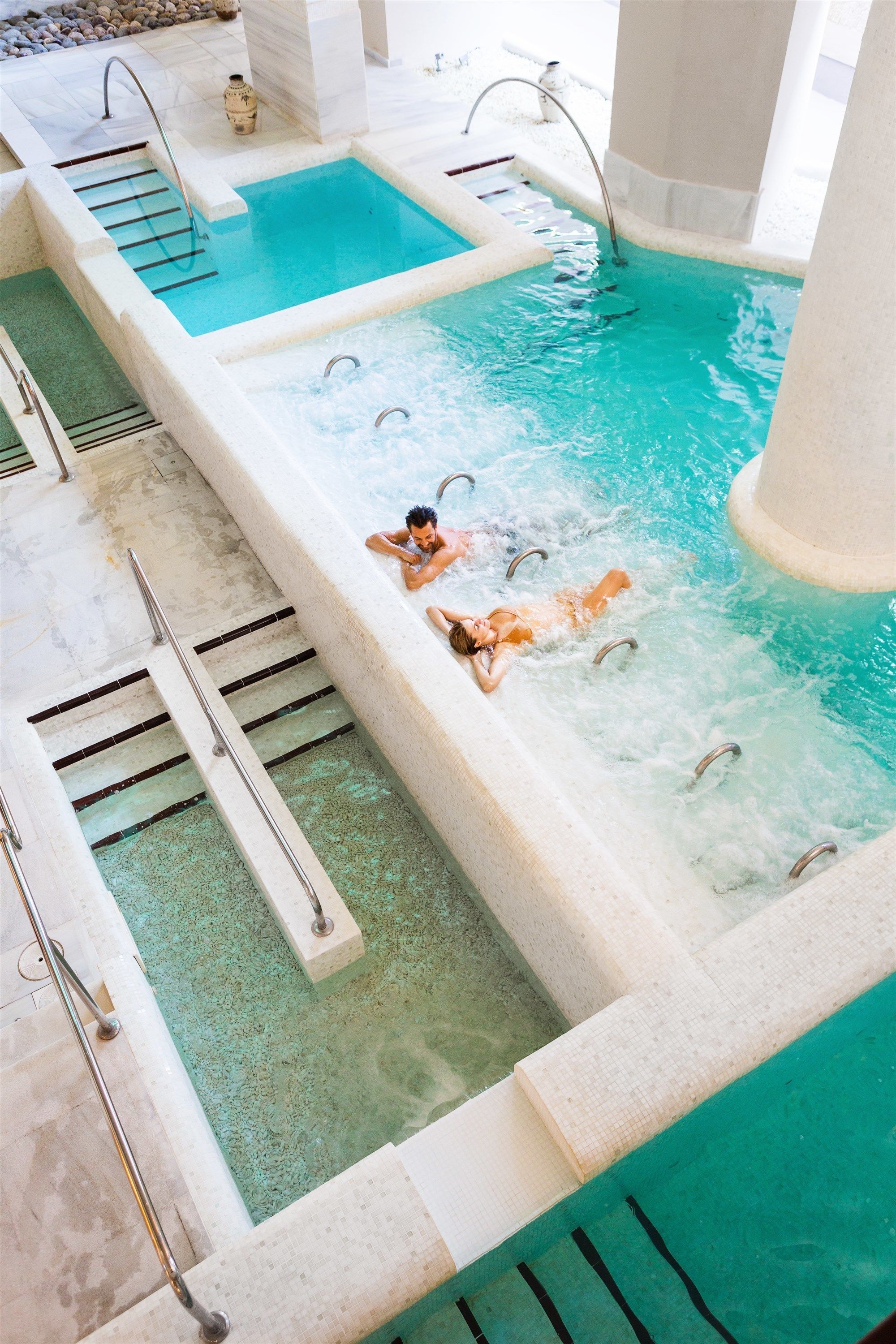 Un área de spa con varios jacuzzis y una piscina.