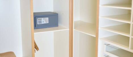 A walk-in closet with open shelving, a hanging rod, and a storage box.