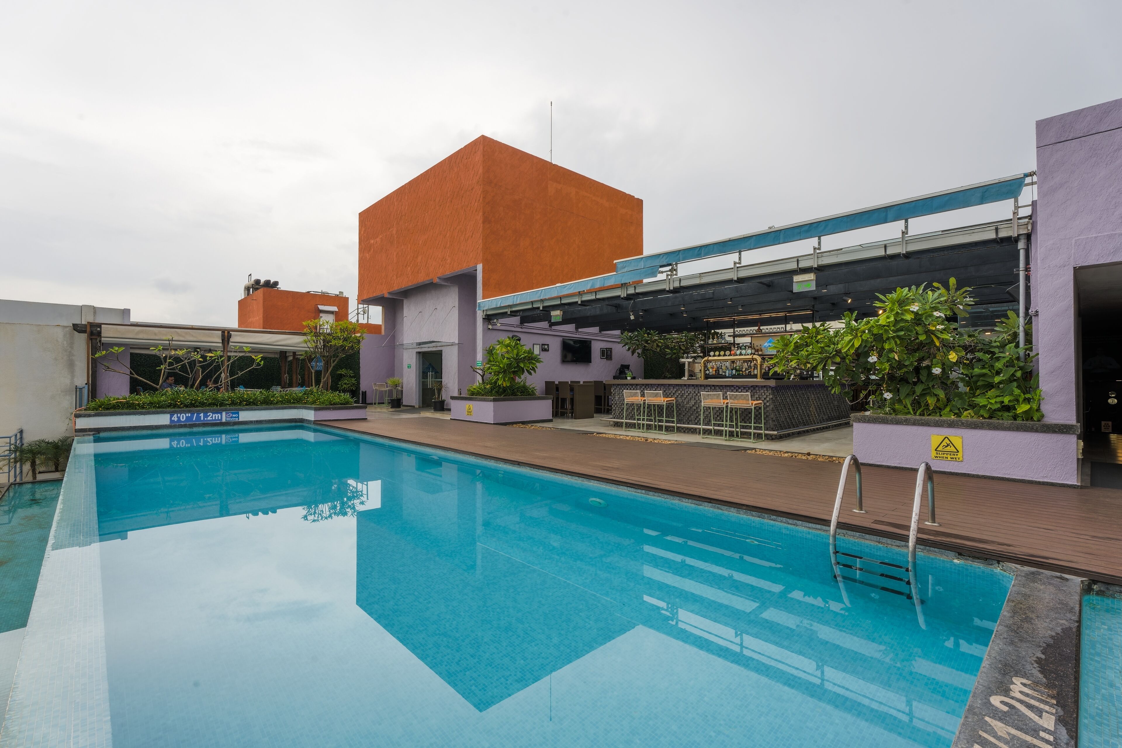 A swimming pool with a bar area and a covered seating space.