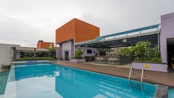 A swimming pool with a bar area and a covered seating space.