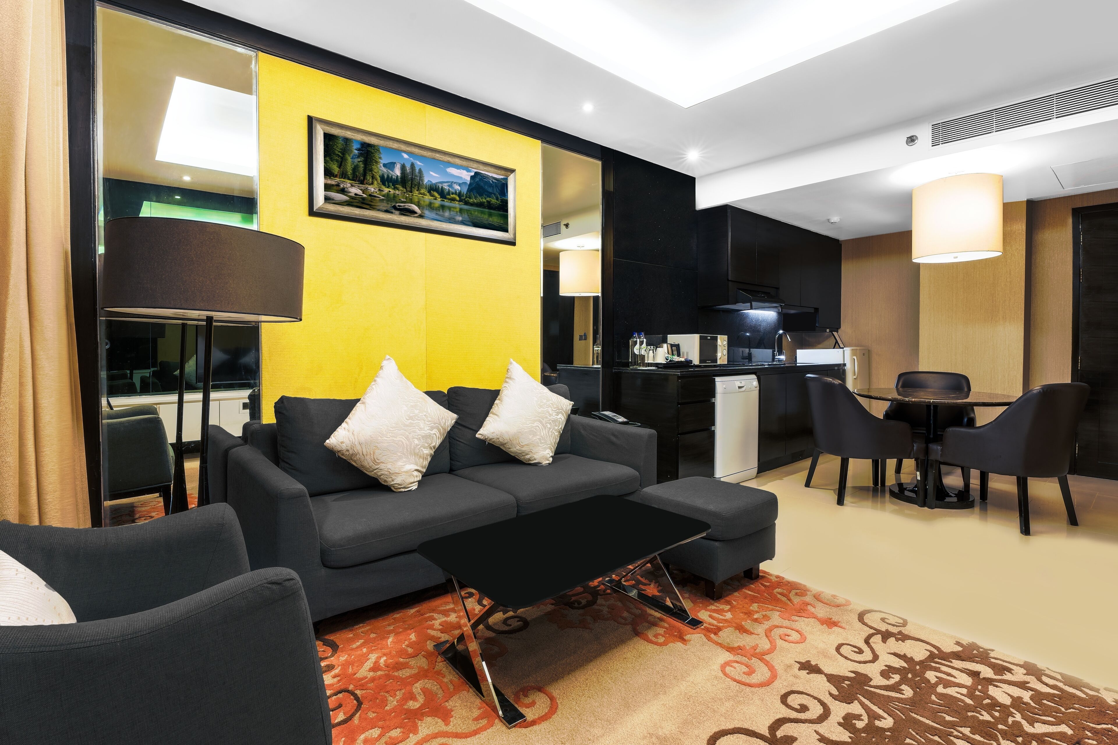 A modern living room with a sofa, coffee table, and dining area.