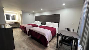 Una habitación de hotel con dos camas, un escritorio y una silla.