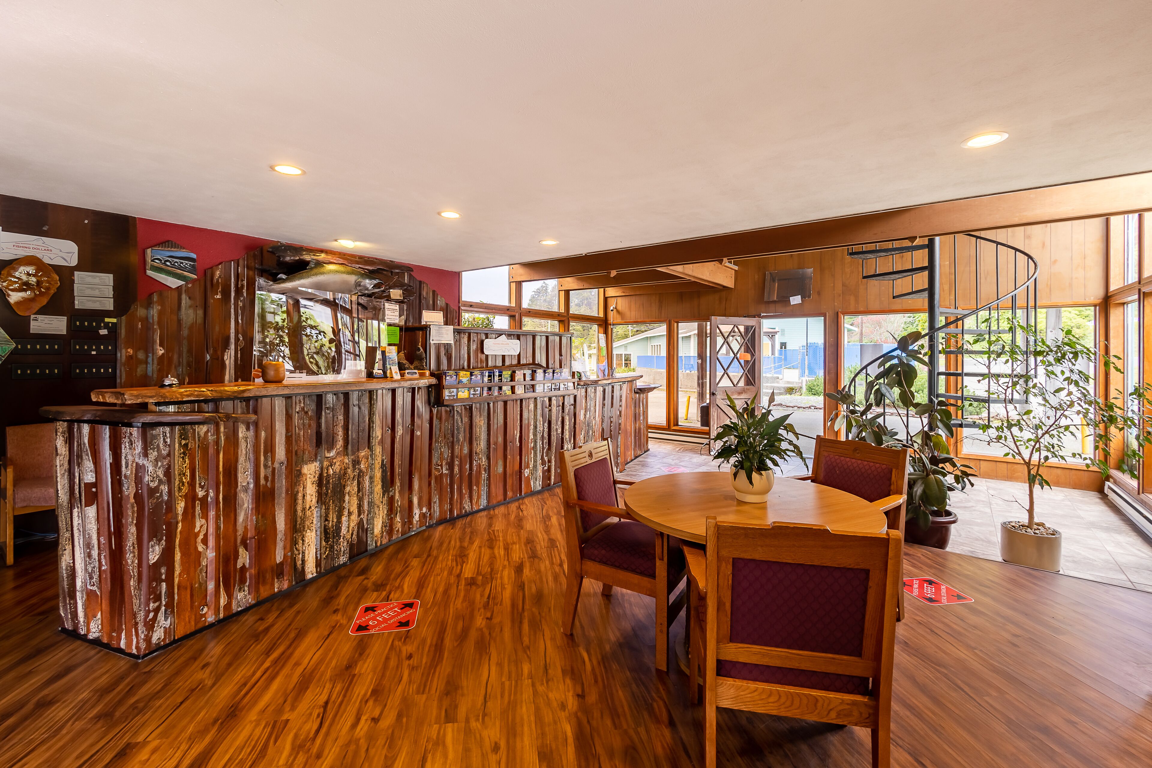 A wooden bar area with a counter, seating, and large windows.