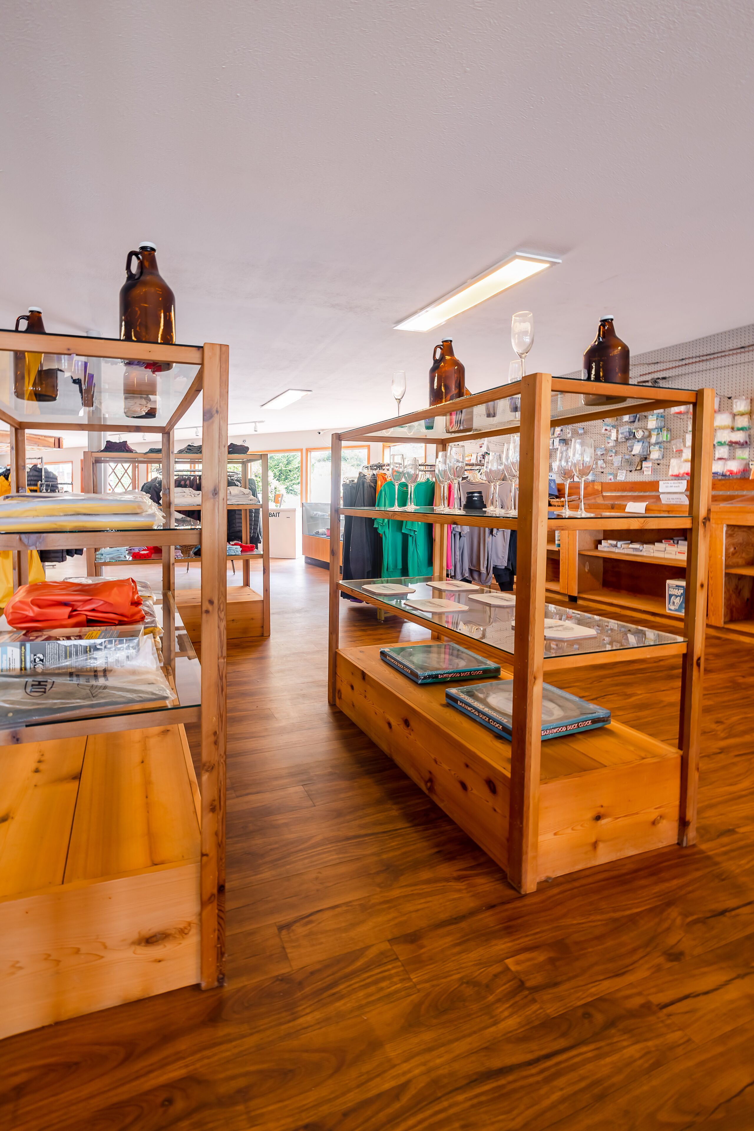 Una tienda con estantes de madera exhibiendo ropa y cristalería.