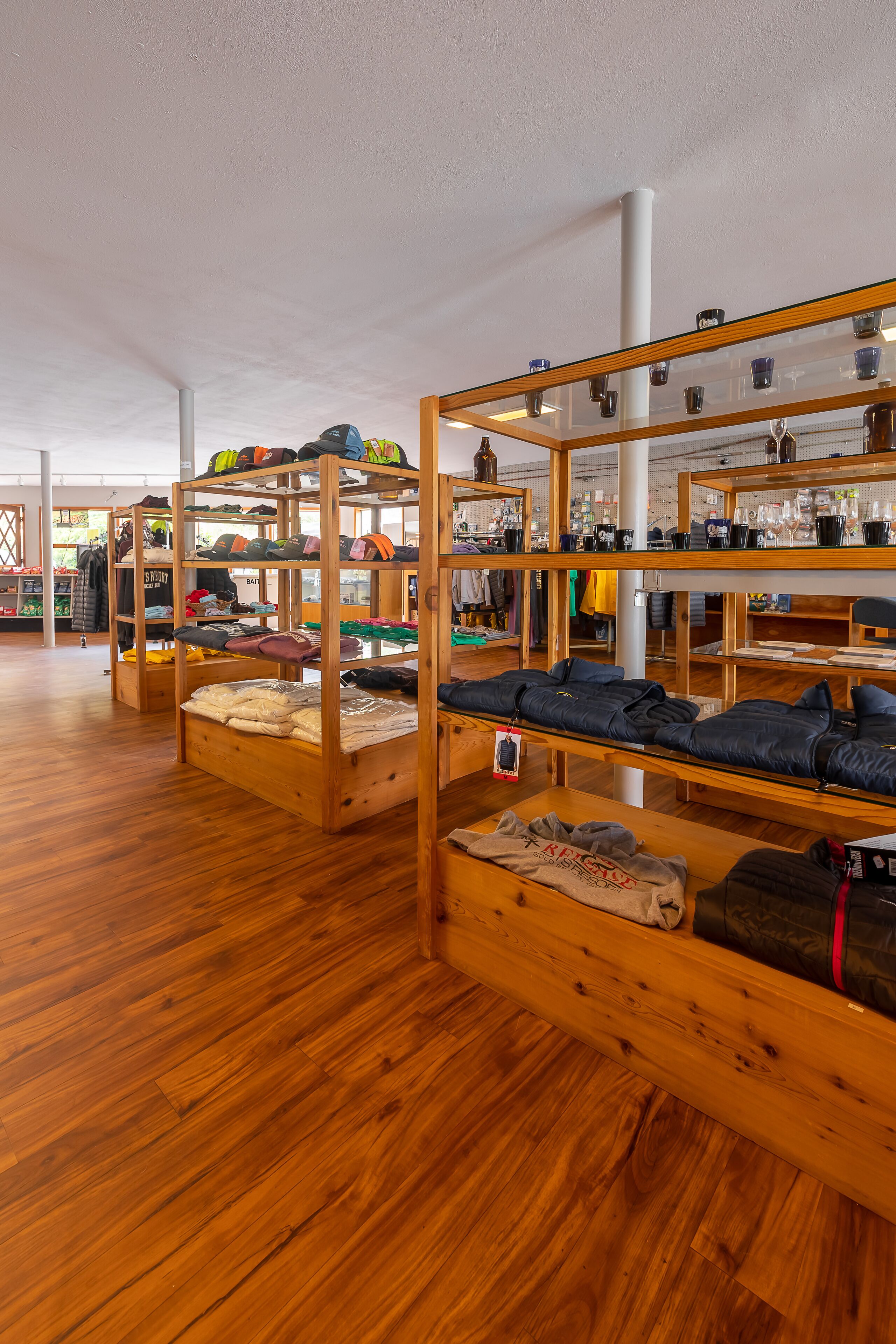 Bunk beds with storage shelves, wooden flooring, and a ceiling with visible structural beams.