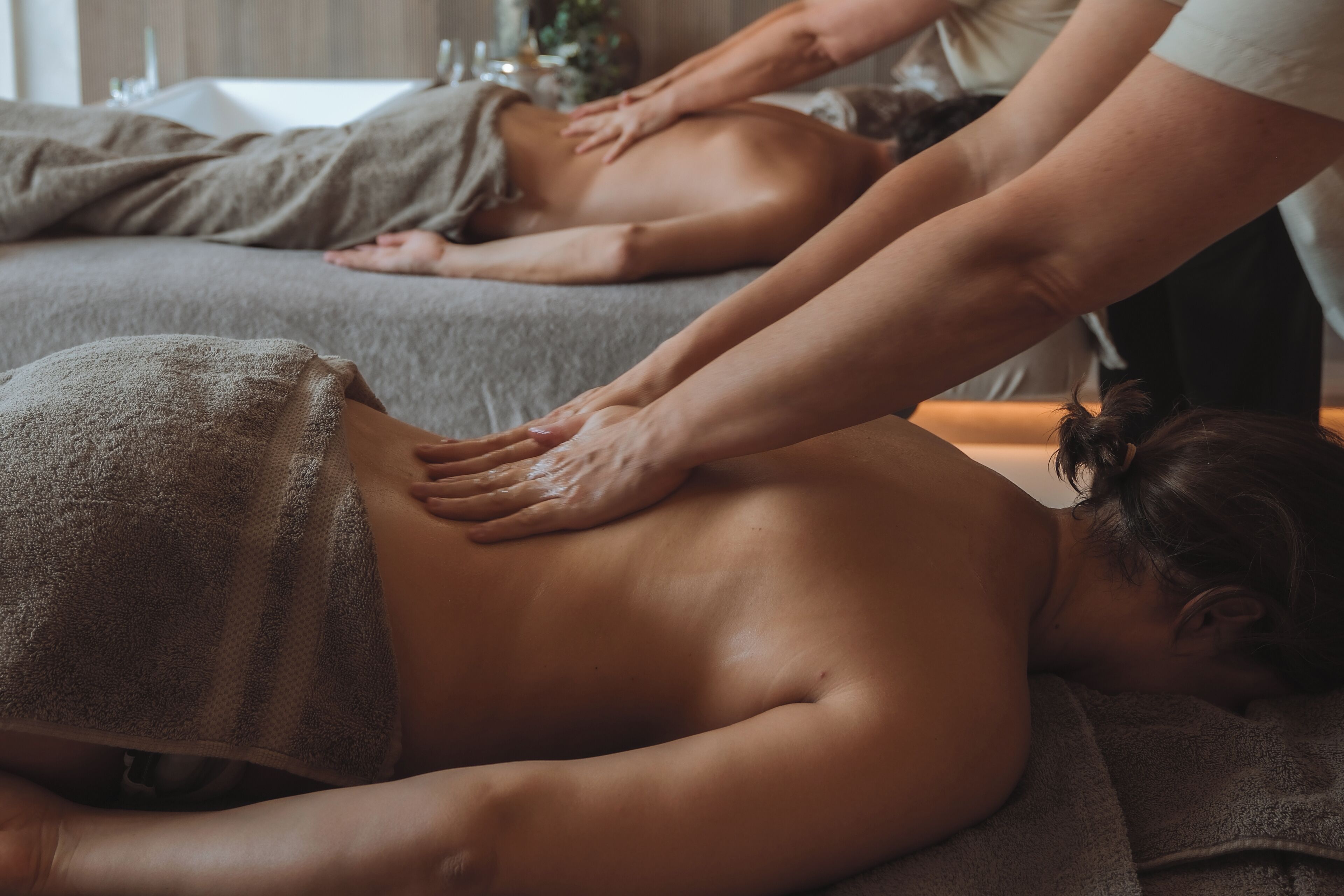 Sesión de terapia de masajes en una habitación con cama y camilla.