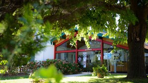 A building with a red and blue facade, a visible entrance, and a sign that reads "ACCUEIL". - Domaine du Pignada (Anglet)