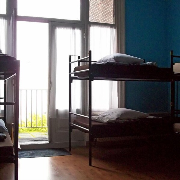 Un dormitorio con literas, una ventana y una puerta que da a un área exterior.
