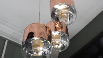 Een plafondlamp met drie bolvormige glazen lampenkappen en koperkleurige details.