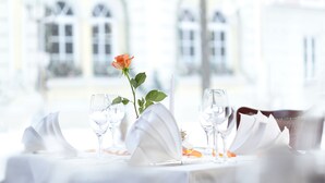 A table set for dining with a rose and glasses, in a room with arched windows. - Kneipp- Kur- und Tagungshotel Luitpold (Bad Woerishofen)