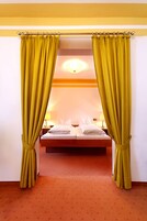 Una habitación de hotel con una cama, cortinas y una mesita de noche.
