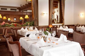 Un restaurante con manteles blancos, mesas elegantemente dispuestas y sillas.