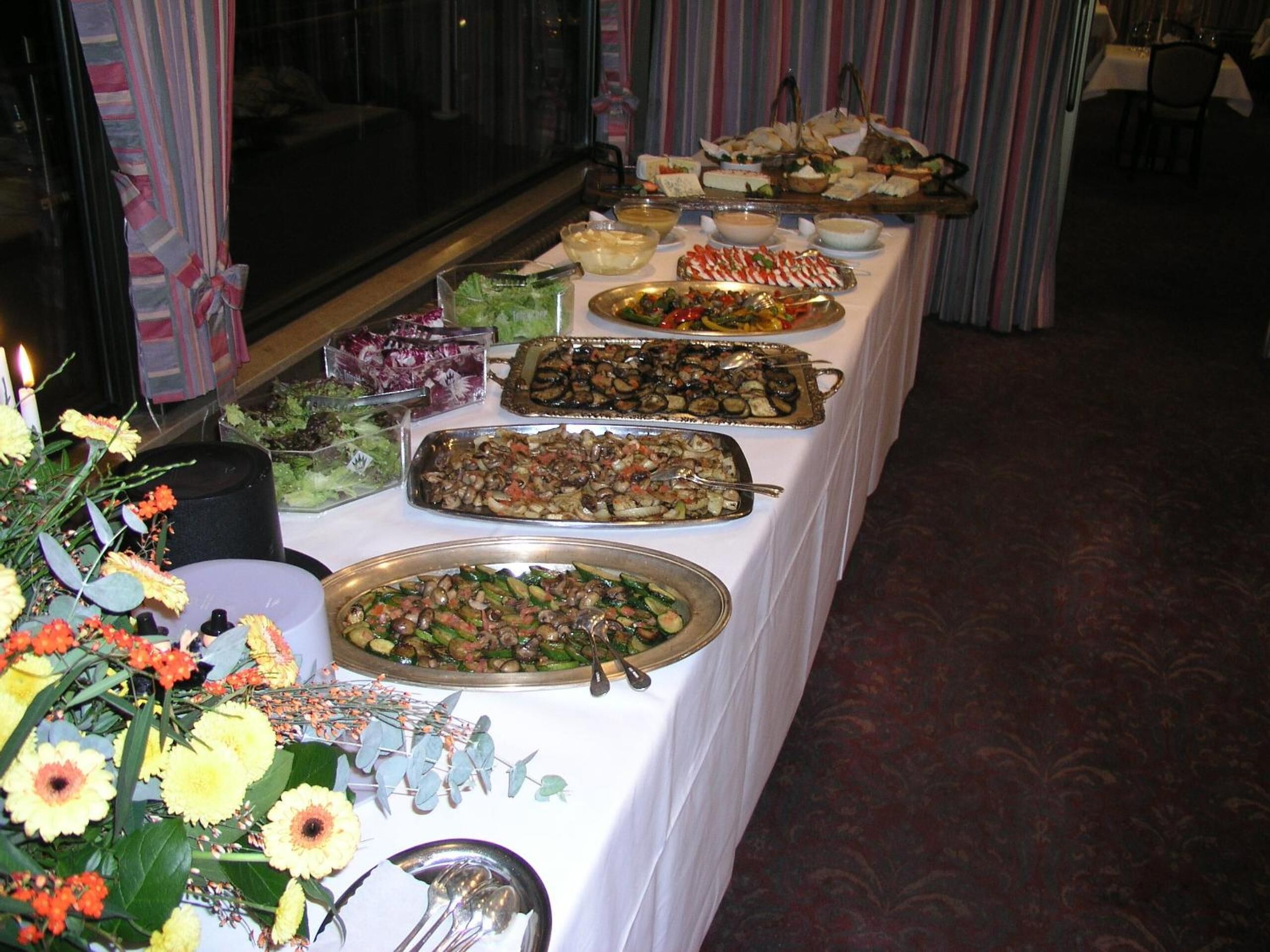 En buffet med forskellige retter og en blomsteropsætning.