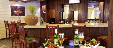A restaurant with wooden furniture, a bar area, and a large decorative plant.