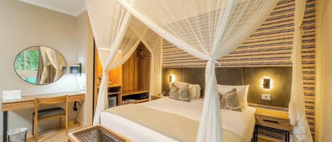 A bedroom with a bed, bedside tables, a desk, a chair, a mirror, and a window with curtains.
