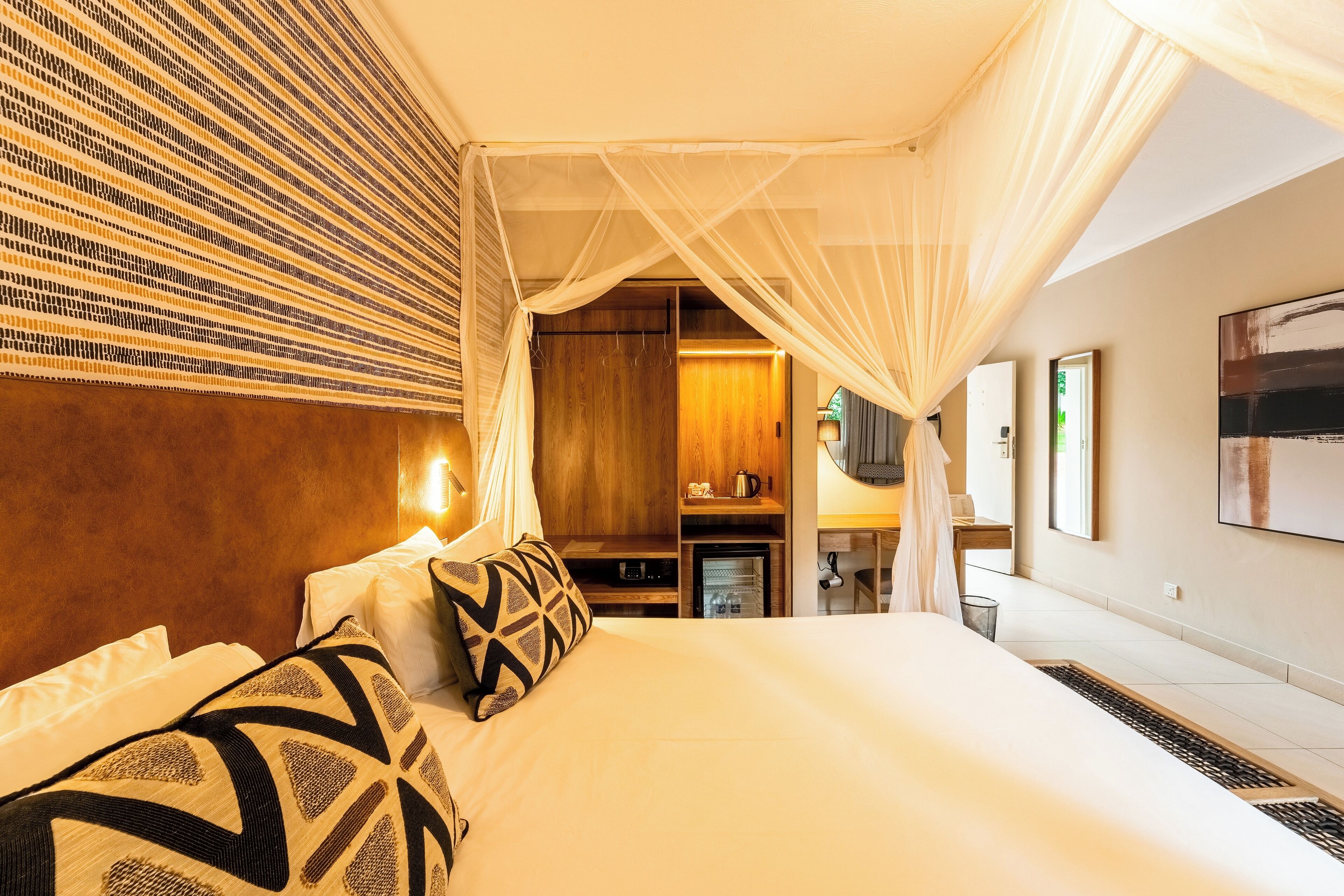 A hotel room with a bed, a wardrobe, a desk, and a television.
