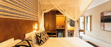 A hotel room with a bed, a wardrobe, a desk, and a television.