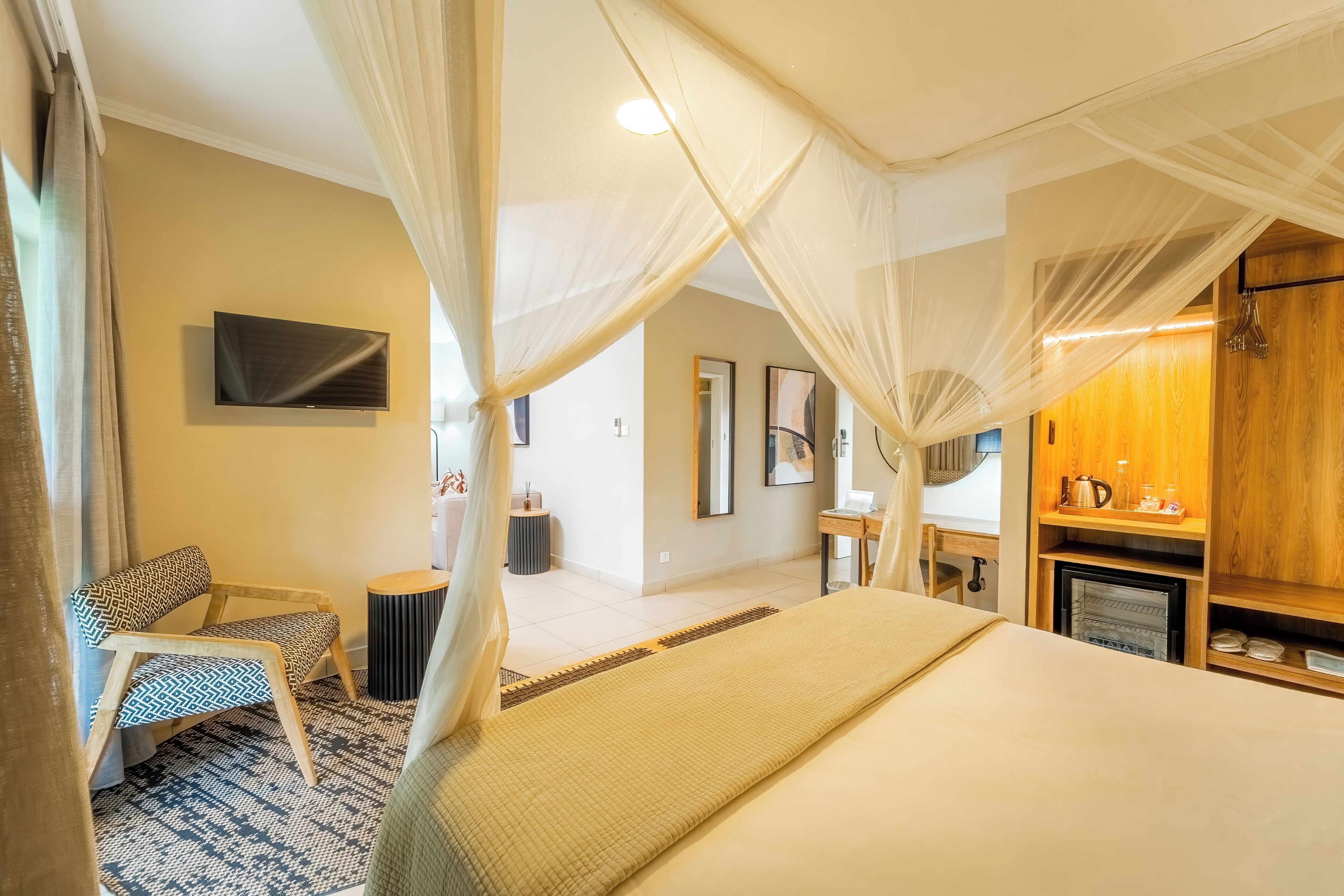 A bedroom with a bed, a chair, a TV, a bedside table, and a wooden cabinet.