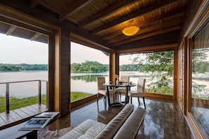 Een houten terras met een tafel en stoelen met uitzicht op een meer.