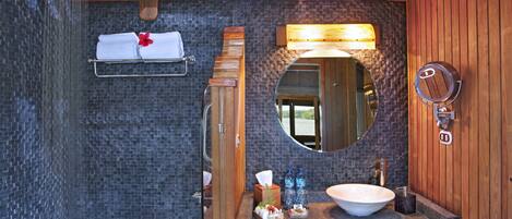 A bathroom with a bathtub, a sink with a large mirror, and a shower.