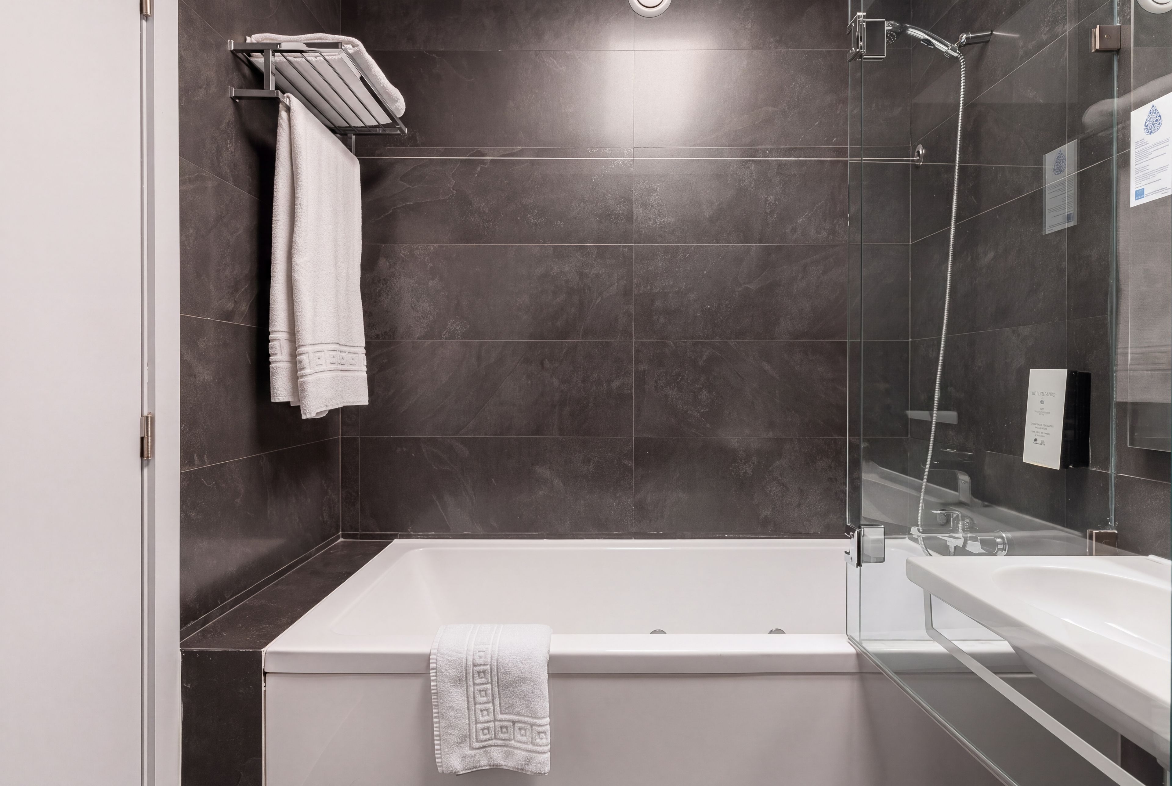 A modern bathroom with a bathtub, a shower, and a sink.