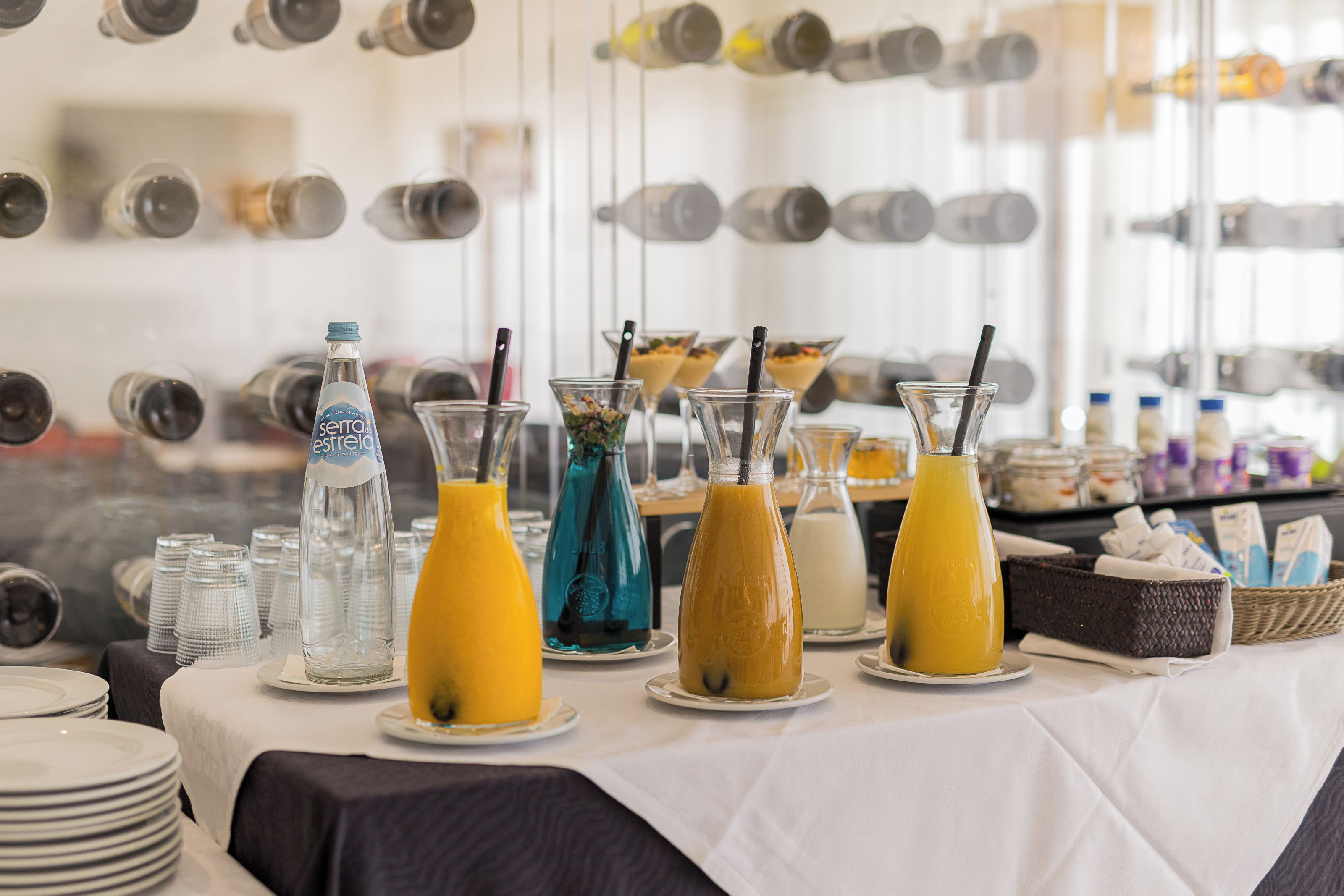 A buffet table with various beverages and food items.