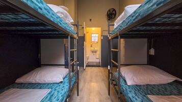 A bunk room with two beds, a sink, and a mirror.
