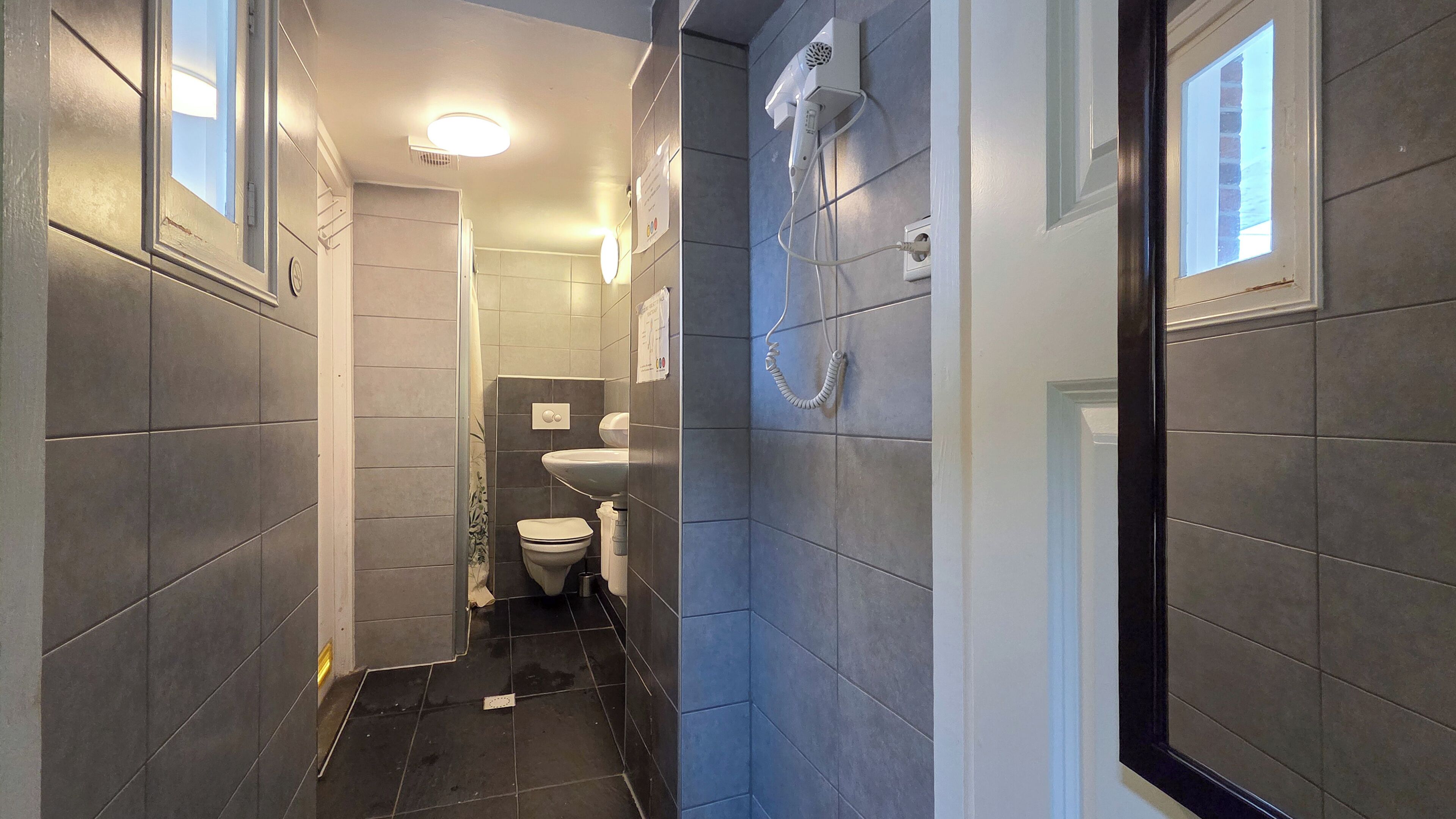 Slaapzaal, alleen voor vrouwen, gedeelde badkamer | Badkamer | Een haardroger, toiletpapier