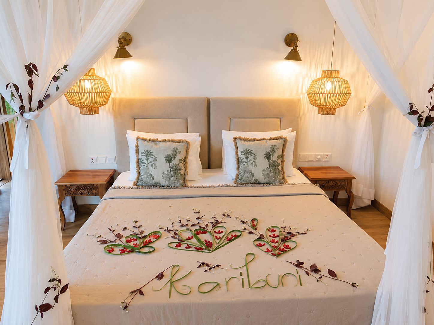 A double bed with a canopy, two bedside tables, and wall-mounted lamps.
