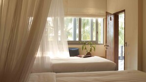 Un dormitorio con dos camas, una ventana con cortinas, una mesita de noche con una planta y una puerta que da a un área exterior.